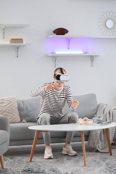 Fiatal férfi VR szemüveget használ otthon - Fotó, kép