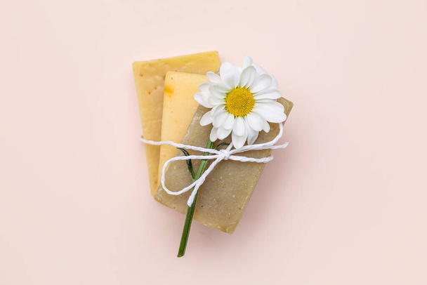 Soap bars with chamomile flower tied with rope on color background - Fotó, kép