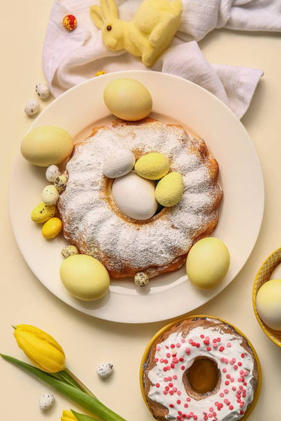 Σύνθεση με νόστιμα κέικ Πάσχα, βαμμένα αυγά και τουλίπα λουλούδι στο φόντο χρώμα - Φωτογραφία, εικόνα