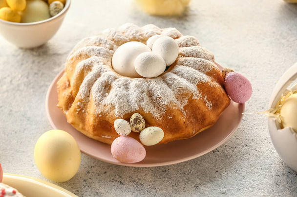 Plate with tasty Easter cake and painted eggs on grey table - Fotografie, Obrázek