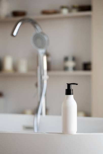 A mock-up of a white dispenser with cosmetics in bathroom. A template for a cream, shampoo or shower gel. - Foto, imagen