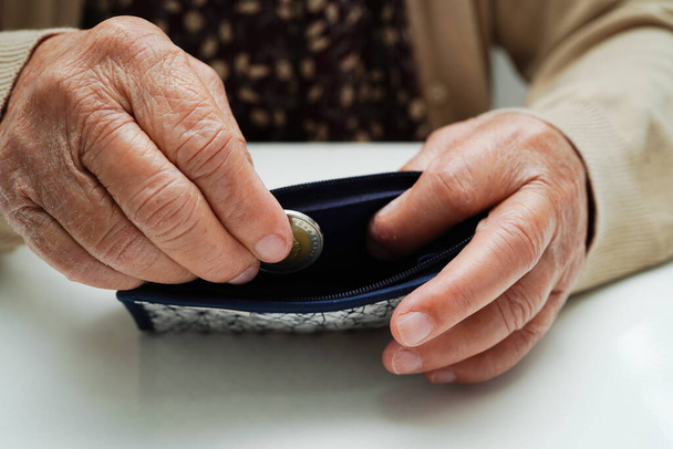 Retired elderly woman counting coins money and worry about monthly expenses and treatment fee payment - Fotó, kép