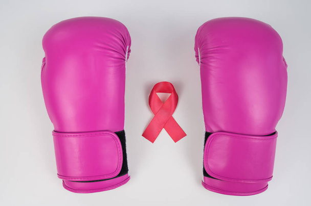 Pink boxing gloves and pink ribbon on a white background. The concept of the fight against breast cancer - Foto, afbeelding
