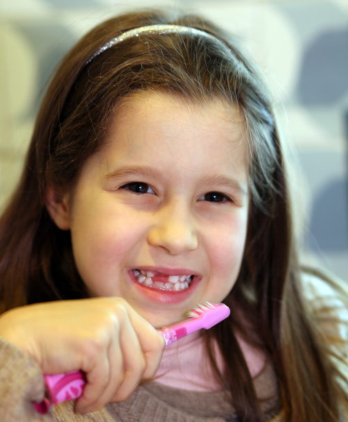 young girl without a tooth while brushing teeth in the bathroom - Photo, Image