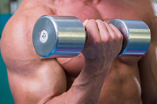 Muscular man working out with dumbbells - Photo, Image