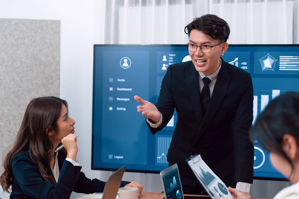 Confidence and asian businessman give presentation on financial analyzed by business intelligence in dashboard report to other people in board room meeting to promote harmony in workplace. - Photo, Image