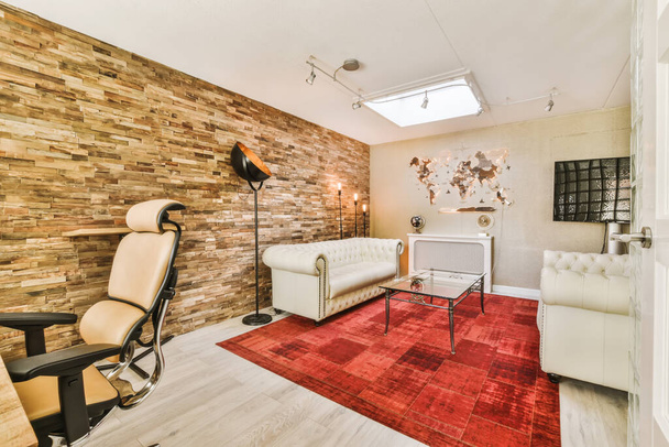 un soggiorno con pannelli in legno alle pareti e sedie in pelle bianca di fronte ai tappeti della zona - Foto, immagini