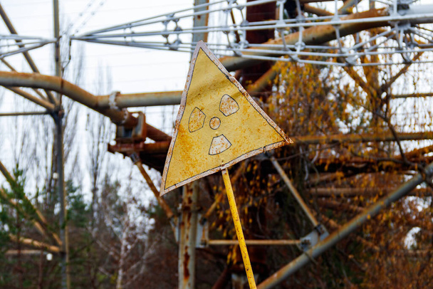 Radiation warning sign in front of Duga, a Soviet over-the-horizon (OTH) radar system as part of the Soviet anti-ballistic missile early-warning network, inside the Chernobyl Exclusion Zone in Ukraine - Fotoğraf, Görsel