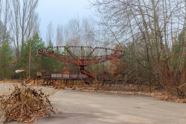 Old rusty carousel in amusement park of ghost town Pripyat in Chernobyl Exclusion Zone, Ukraine - 写真・画像