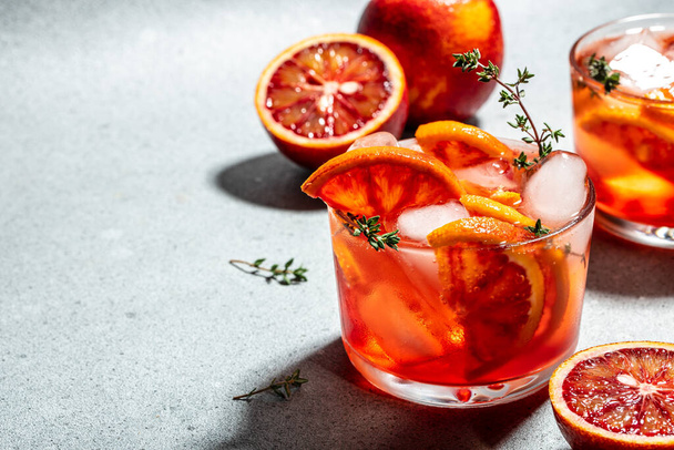 Cóctel rojo con naranjas rojas sicilianas sobre un fondo claro, concepto de verano, - Foto, imagen