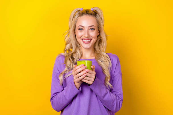 Photo of cheerful funny woman wear violet shirt enjoying tasty beverage isolated yellow color background. - 写真・画像