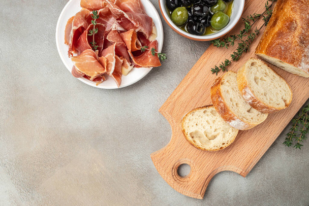 Antipasto of ham, crostini with prosciutto, olives and glass of red wine. - Φωτογραφία, εικόνα