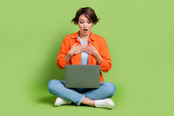 Full length photo of pretty impressed woman wear denim jacket reading news modern device isolated green color background. - Zdjęcie, obraz