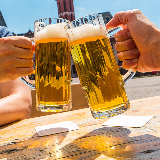 Deux mains cliquetis verres à bière en été - Photo, image