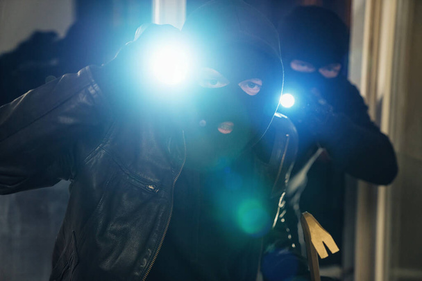 Equipo de ladrón criminal irrumpiendo y entrando en la casa de una víctima por la noche - Foto, Imagen