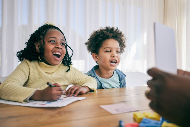 Ouders helpen kinderen met huiswerk, schoolactiviteiten en leren aan de balie met papier, teken- en leskaarten. Zwart gezin, onderwijs en gelukkige jongen en meisje glimlach voor creatief onderwijs thuis. - Foto, afbeelding