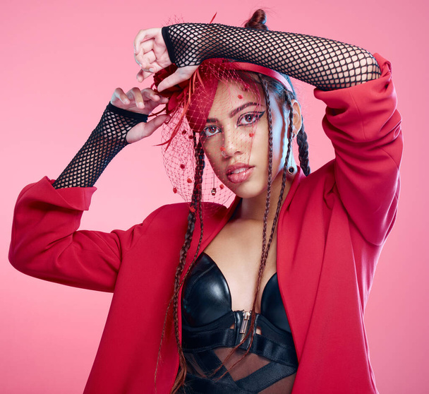 Woman, studio portrait and leather fashion with punk, rock or heavy metal aesthetic by pink background. Gen z girl, fantasy and net clothes with beauty, makeup and cosmetics with trippy creativity. - Foto, immagini
