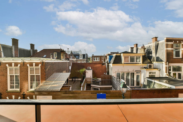 néhány épület a város kék ég és fehér felhők felettük, mint látható egy lakás tetőteraszáról - Fotó, kép