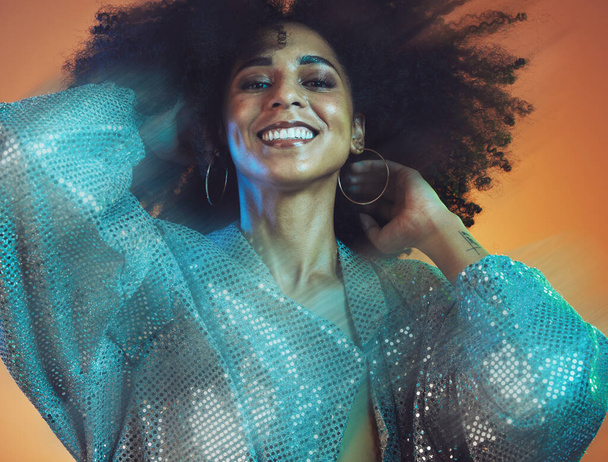 Beauty, hair and black woman with blur, face and movement with makeup and glitter against studio background. Hair care, natural curly hair and cosmetics with happiness and portrait, disco and fashion. - Foto, Imagen