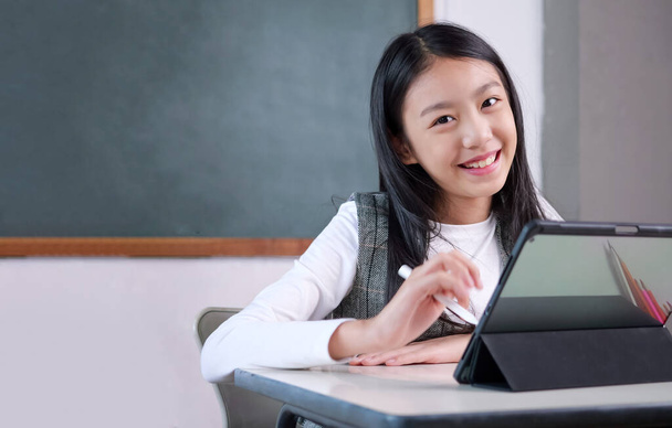Cheerful schoolgirl in the classroom, Happy student studying with teacher in classroom at school, Learning development, Back to school concept - Photo, Image