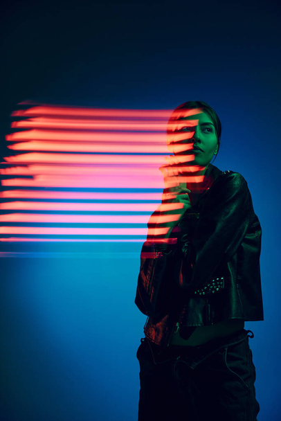 Kauneus. Puolipitkä muotokuva nuori tyylikäs nainen poseeraa tummansininen tausta neon sekoittaa valon linjat. Nykytaiteen, muodin, kyberpunkin, futurismin käsite - Valokuva, kuva