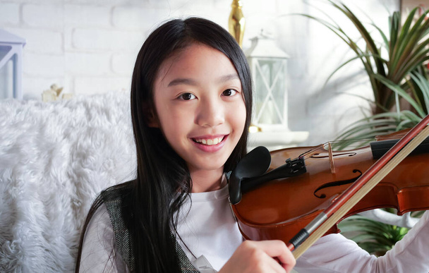 Portrait eines Mädchens, das zu Hause Geige spielt, Kind mit Liedern Portrait, Hausunterricht mit Musik, Aktivitäten für Kinder zu Hause, Video-Chat-Konferenzstunde und Online-Musikunterricht, Klassik - Foto, Bild