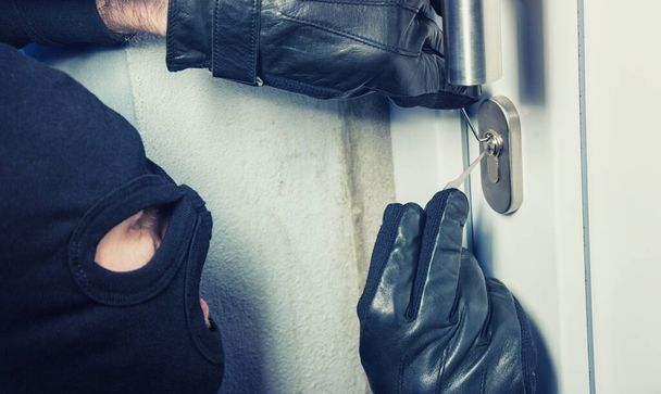 burglar using Lock-picker to open a victim's door - Foto, immagini