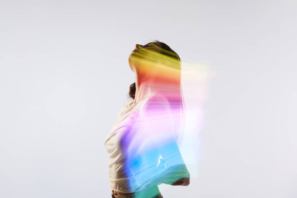 Aspiracja. Sylwetka portret młodej uroczej kobiety pozowanie na białym tle z mieszanym neonem kolorowe światło na jej ciele. Pojęcie sztuki współczesnej, piękna, mody, futuryzmu - Zdjęcie, obraz