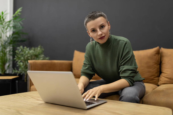 mujer trabajando remotamente en un ordenador portátil para un proyecto profesional. - Foto, Imagen