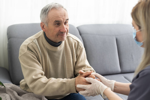 Nurse holding hand of senior man in rest home - Photo, Image