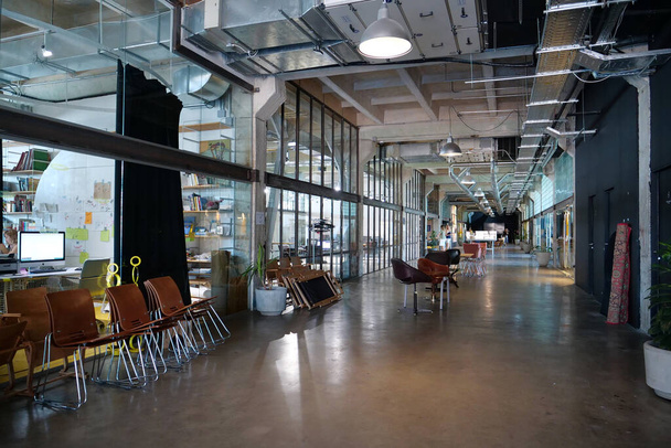 IVANO-FRANKIVSK, UKRAINE, AUGUST 20, 2022: People in coworking space PROMPRYLAD in former factory workshop. Coworking - arrangement in which workers of many companies share an office space - Foto, Imagen