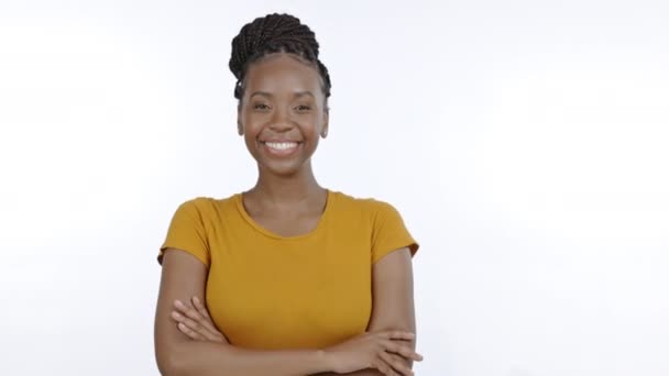 Gekreuzte Arme, Lächeln und Porträt einer schwarzen Frau im Studio auf weißem Hintergrund für Zuversicht, glücklich und aufgeregt. Führungspersönlichkeit, Schönheit und isoliertes Mädchen mit positiver Einstellung, Erfolgsdenken und Wohlbefinden. - Filmmaterial, Video
