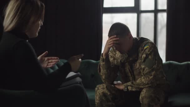 Egy fiatal ukrán katona depresszió miatt fordult pszichoterapeutához, amit az ellenségeskedésben való részvétel provokált. Egy férfi katonai egyenruhában depresszióban hallgatja a... - Felvétel, videó