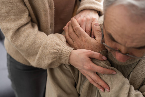 Kopfschuss alten männlichen Rentner in Reha-Verfahren mit fürsorglichen jungen Physiotherapeuten beteiligt. Rentner mit Gehbehinderung ist dankbar für professionelle Hilfe - Foto, Bild