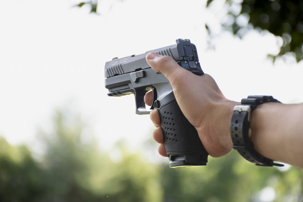 Isolated 9mm pistol gun holding in right hand of gun shooter with clipping paths. - Φωτογραφία, εικόνα