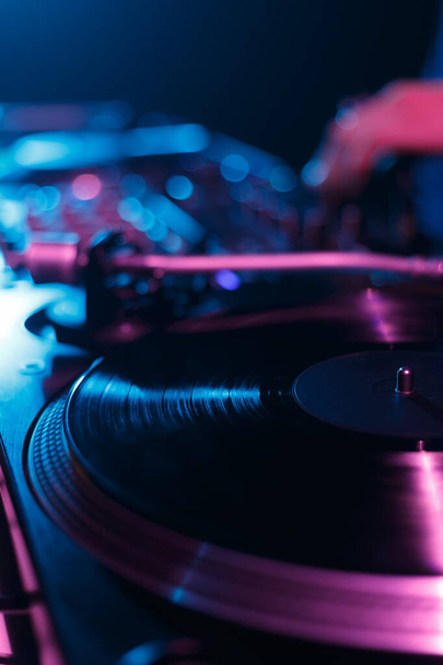 DJ turntable playing vinyl record with music on hip hop party in night club - Foto, Imagen