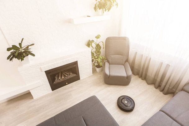 Aspirador robótico no piso de madeira laminado na sala de estar - Foto, Imagem