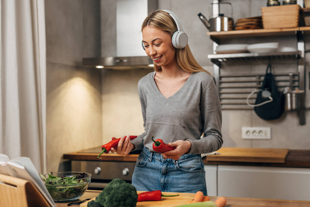 A blond caucasian woman is cooking a healthy meal - Foto, immagini