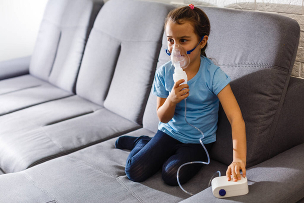 Petite fille faisant inhalation avec nébuliseur à la maison. enfant asthme inhalateur nébuliseur vapeur mal toux concept Horizontal - Photo, image