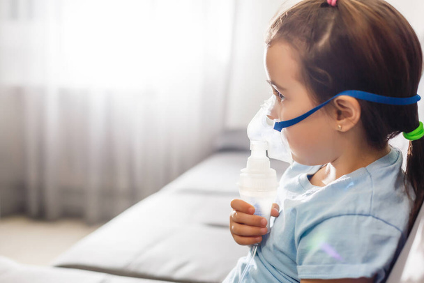 Petite fille dans un masque, traite les voies respiratoires avec un nébuliseur à la maison
 - Photo, image