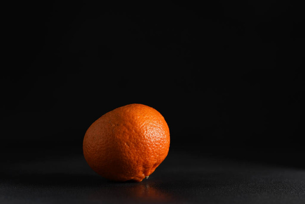 Juicy ripe Mandarin on a Black Background. Isolate. Copy space - Foto, afbeelding