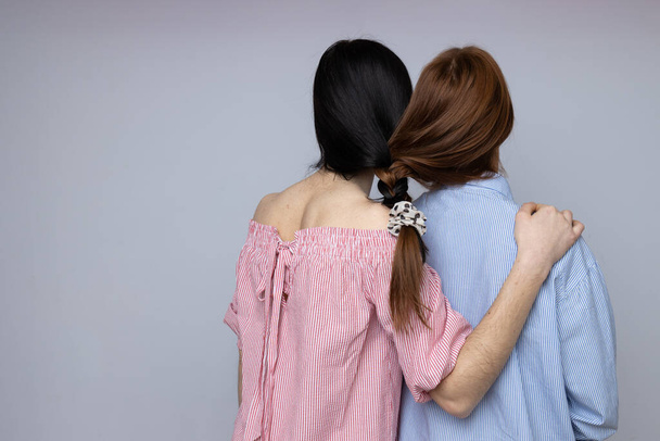 Two beautiful young women, sisters - twins on light gray background - Foto, Imagem