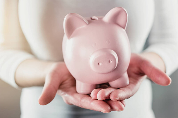 woman holding a piggy bank - money investments concept image - Foto, Imagem