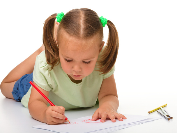Little girl is drawing while laying on the floor - Photo, image