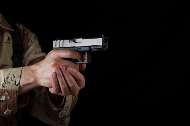 Αρσενικό στρατιώτης δείχνει το όπλο του στο σκοτάδι - Φωτογραφία, εικόνα
