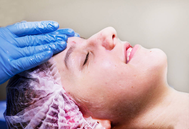  Gesichtsmassage mit ätherischen Ölen für ein junges Mädchen in einem Wellness-Salon. - Foto, Bild