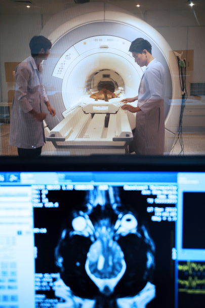 Veterinarian doctor working in MRI scanner room with moniter foreground - Foto, immagini