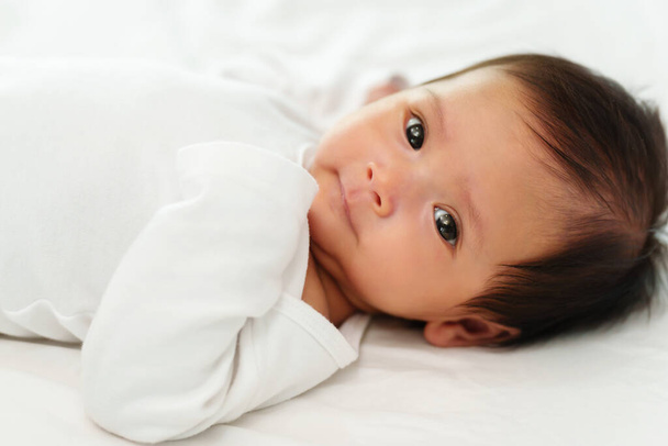 newborn baby lying on a white bed - Φωτογραφία, εικόνα