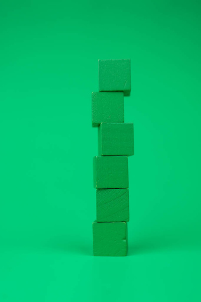 Tower of empty green blocks with free space for you text on a green background. Vertical image - Fotó, kép
