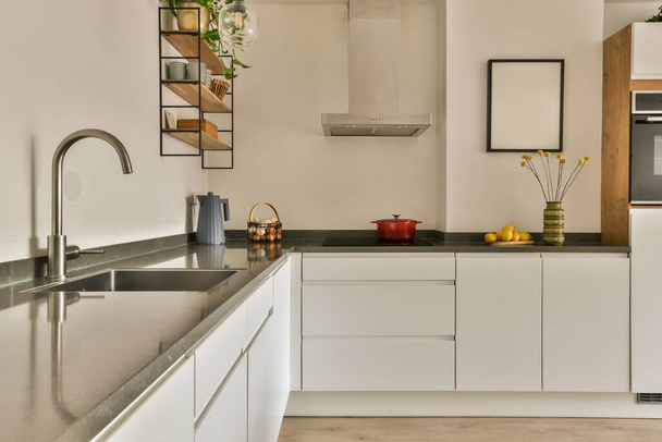 a modern kitchen with white cabinets and black counter tops in the center of the image is an oven, dishwasher, sink - Fotoğraf, Görsel